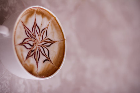 Cup of coffee with latte art on beige background.の写真素材