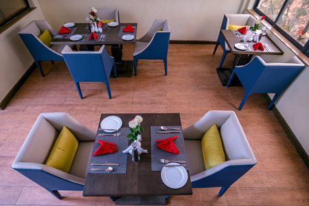Interior of a modern restaurant with blue and yellow chairs and tables.の写真素材