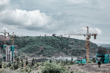 Construction site with workers and cranes at the top of the mountain