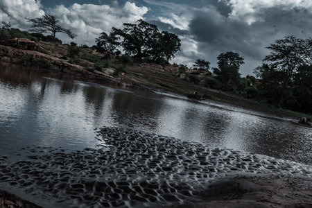 River in the evening with dark clouds and blue sky, Thailand.