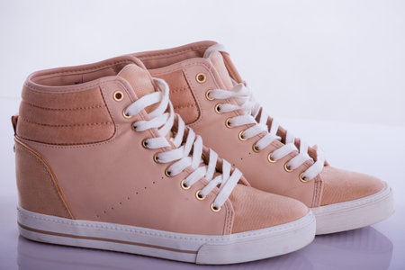 Pair of beige sneakers on a white background. Side view.