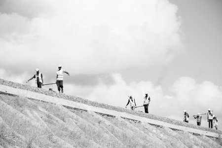 Workers are working on the top of the mountain. Black and white