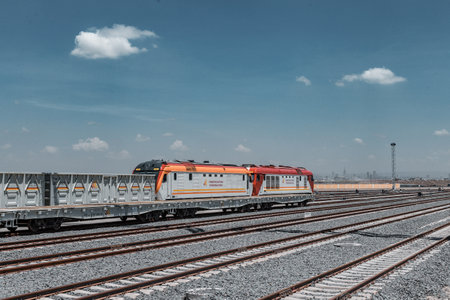Train at the railway station on a background of blue sky with cloudsの写真素材