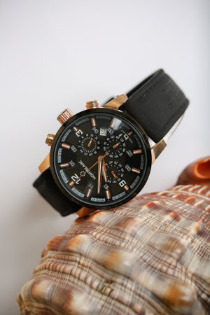 Wristwatch with black dial and brown leather strap on the shell