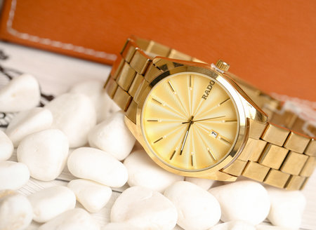 Wristwatch on a background of white stones and a leather walletの写真素材