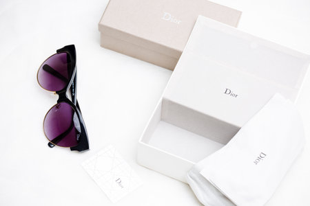 Sunglasses and a box of clothes on a white background.