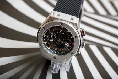 Wristwatch on a black and white striped background. Close-up.