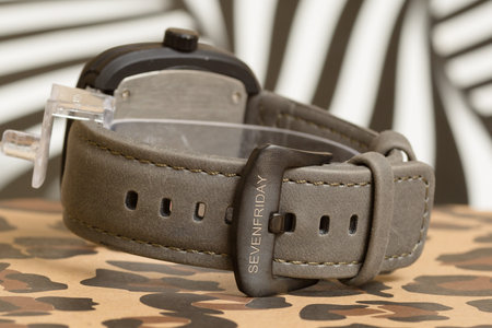Fashionable men's watch with a black strap on a camouflage background