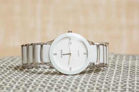 Luxury wrist watch with white dial and stainless steel bracelet.