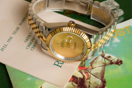Luxury gold wristwatch on a green background. Close-up.の写真素材