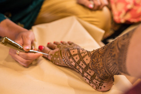 Close up of henna tattoo being applied on a womans handの写真素材
