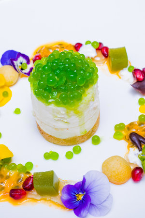 Cake with green jelly and fruit on a white background in the restaurantの写真素材