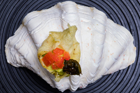 Sushi roll with salmon, caviar and vegetables on a black background