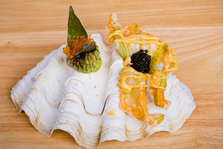 Sushi roll with caviar and wasabi on wooden background.