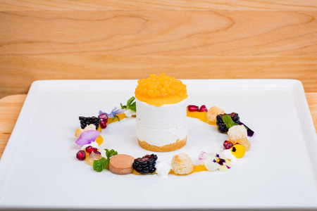 Fruit cake with cream and caviar on white plate in restaurantの写真素材