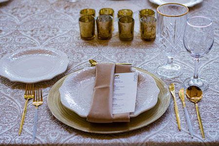 Wedding table set with gold cutlery and napkin