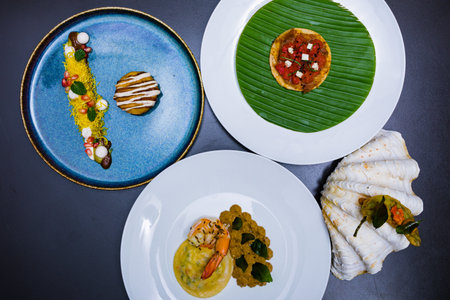 Close up view of four plates with fish and vegetables on black background