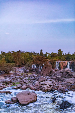 Beautiful waterfall in the forest at sunset. The concept of active and photo tourism