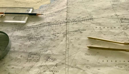 View of the navigation chart with binocular, divider , pencil and a scale at bridge on board a ship at seaの写真素材