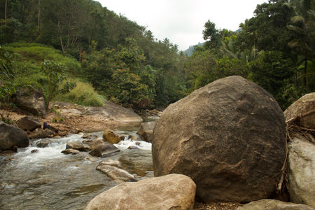 This clean stream is in the western ghats of India. This location was found during a recent visit after monsoon season. The stream is filled with large rocks at many places came from top areas during landslidesの写真素材