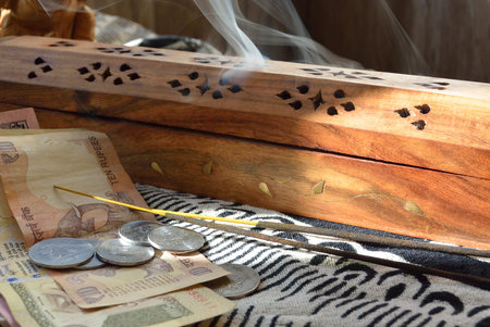 Indian rupees and incense burner