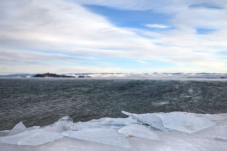 Transparent ice floes at frozen coast of stormy lake in winterの写真素材