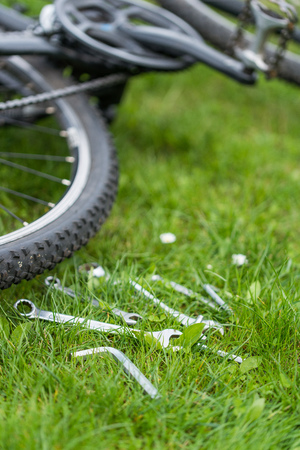 set of keys to repair the bike lying on the grass.の写真素材