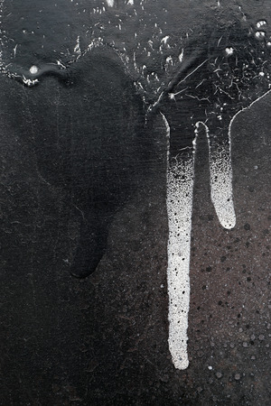 Rust-covered fence  with dripping black and white paint -  grunge iron textured abstract backgroundの写真素材