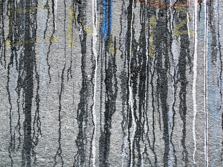 Spilled,dripping white,  black,  red,  yellow and blue paint on a grey wall-abstract art backgroundの写真素材