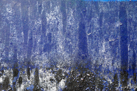 Small part of plastered hoarse,scratched and peeled surface area with blue,white and black paint -Abstract background-Close upの写真素材