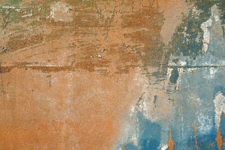 Small part of plastered hoarse,scratched and peeled surface area with blue and yellowish-brown paint -Abstract background-Close upの写真素材