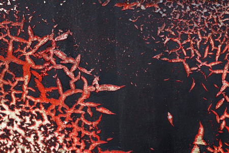 Close up,macro photography of cracked red and white paint on grunge rough black surface-small part of dirty patina metal fance-abstract textured background with space for copy textの写真素材