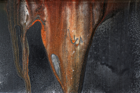 Close up of rusted, corroded old grunge rough  metal surface with rust stains - abstract textured brown, black and orange backgroundの写真素材