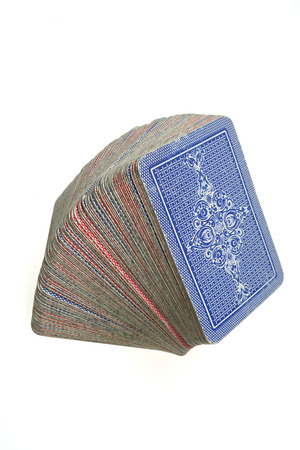 Stacked deck of face down cards isolated on white background
Stacked pile of old blue and red cards - face down.
Standard  French deck of 52 playing cards.
Isolated on white background.の写真素材