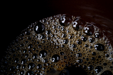 Macro of small bubbles in a coffee cup.
Black coffee background, texture.
Close up, of espresso foam, froth.
Space for copy text.の写真素材