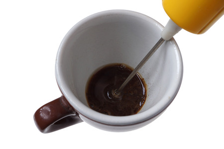 Electric beater and a cup isolated on white. 
Handheld utensil, coffee frother and foam maker.
Homemade instant coffee conceptの写真素材
