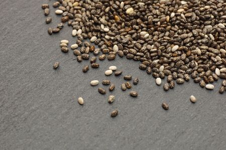 Raw organic chia seeds.
Close up of Salvia hispanica seeds on dark stone background.
Super seeds.  Top view.
Healthy  food concept.の写真素材