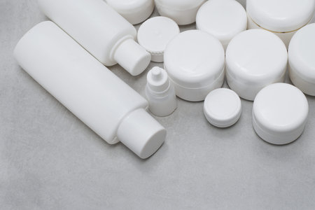 Mock-up.Empty bottles and jars for gel, lotion, cream.White plastic containers for skincare products without labels.Unbranded beauty product package.Green leaves.Cosmetic, pharmacy concept.の写真素材