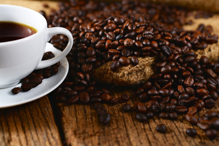 Coffee cup with coffee beans on burlap bag