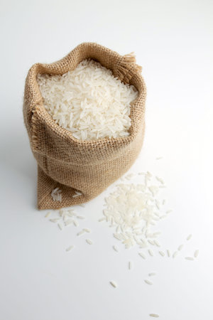rice in burlap sack isolated on whiteの写真素材