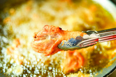 fried chicken cooking from skilletの写真素材