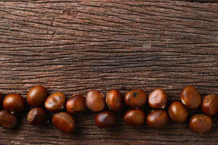roasted chestnuts on wood backgroundの写真素材