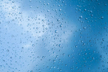 rain drop on glass with sky backgroundの写真素材