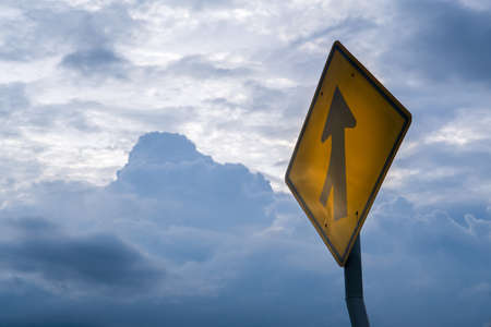 crossroad warning road sign with rain cloud backgroundの写真素材