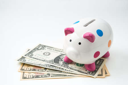 piggy bank with money on white backgroundの写真素材