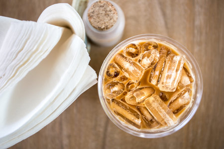 Iced coffee with tissue paper on table