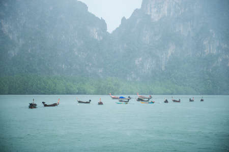 long tail boat with rain at pang-nga bayの写真素材