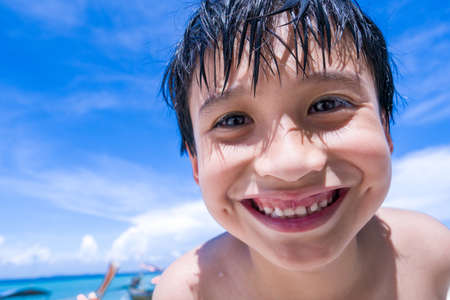 A boy smiling on the beachの写真素材
