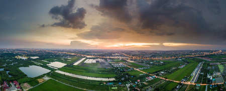 Aerial view panorama of sunset over paddy fields and highway in suburban of Bangkok, Thailandの写真素材