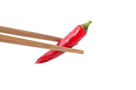 eating red hot pepper with chopsticks isolated on white backgroundの写真素材
